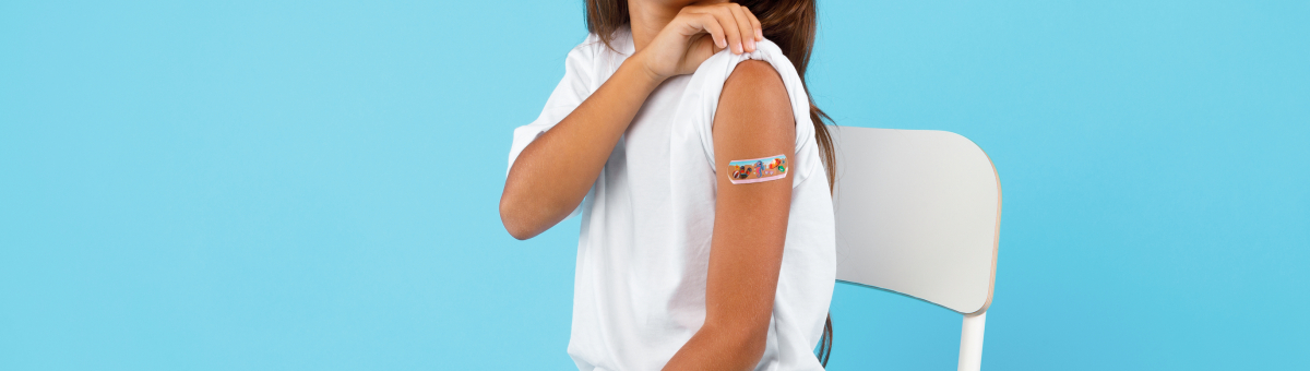 Happy Vaccinated Kid Girl Showing Arm After Vaccination, Blue Background